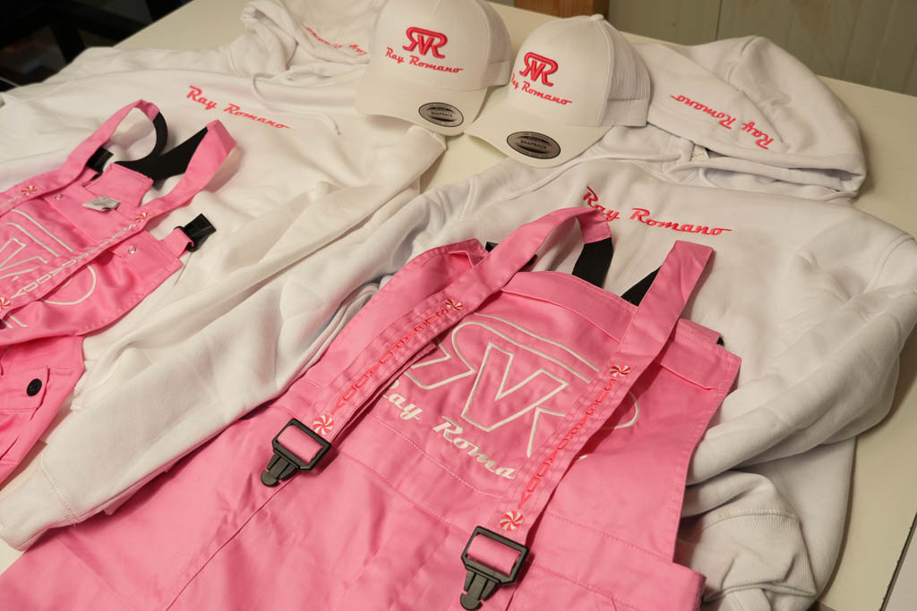 Bedrijfskleding met geborduurd logo: witte hoodies, caps en roze werkbroeken
